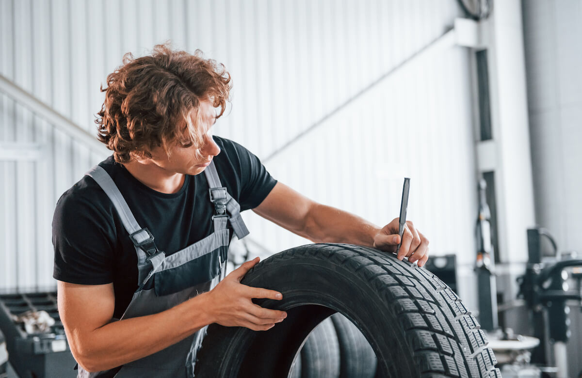 przebita opona w samochodzie wymieniana przez mechanika